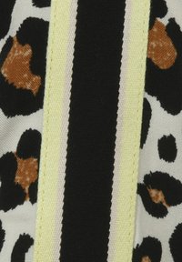 Luipaardprint stof met zwarte, oranje en crèmekleurige vlekken. Zwarte en lichtgele strepen lopen verticaal over het materiaal.