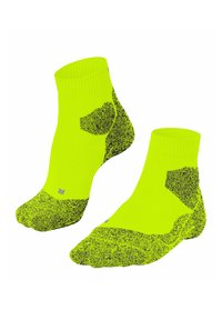 Calze alla caviglia gialle brillanti con motivi a pois neri sulle punte, sui talloni e sui lati, dotate di un polsino a coste e sottili dettagli di cucitura grigia.