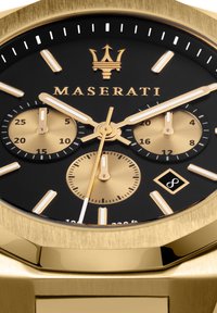 Orologio da polso Maserati dorato con quadrante nero, tre sotto-quadranti dorati, indici delle ore in evidenza e bracciale testurizzato dorato. Dotato di un indicatore di data.