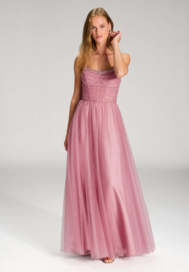 Lang roze tule jurk met een aansluitende lijfje, geplooide details en een met juwelen versierde halslijn. De rok stroomt elegant naar de vloer.