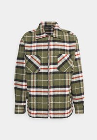 Casaco xadrez verde com detalhes em vermelho e preto, apresentando um fecho frontal com zíper, gola de camisa e dois bolsos com aba. Tecido texturizado.