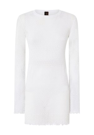 Top blanco de manga larga con un patrón de punto en forma de diamante texturizado y un dobladillo con volantes. La tela es ligera y semitranslúcida.