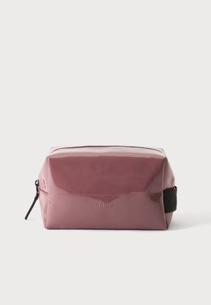 Trousse de toilette rectangulaire mauve brillante avec tirette de fermeture éclair noire et poignée latérale, embossée du logo "RAINS" au centre avant.