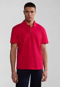 Červené polo tričko z bavlny, s klasickým límečkem, zapínáním na tři knoflíky a malým vyšitým logem na prsou.