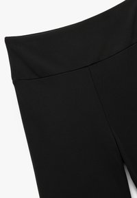 Leggings neri con una cintura ampia e liscia e un design aderente. La texture appare morbida, con una finitura opaca e senza motivi visibili.