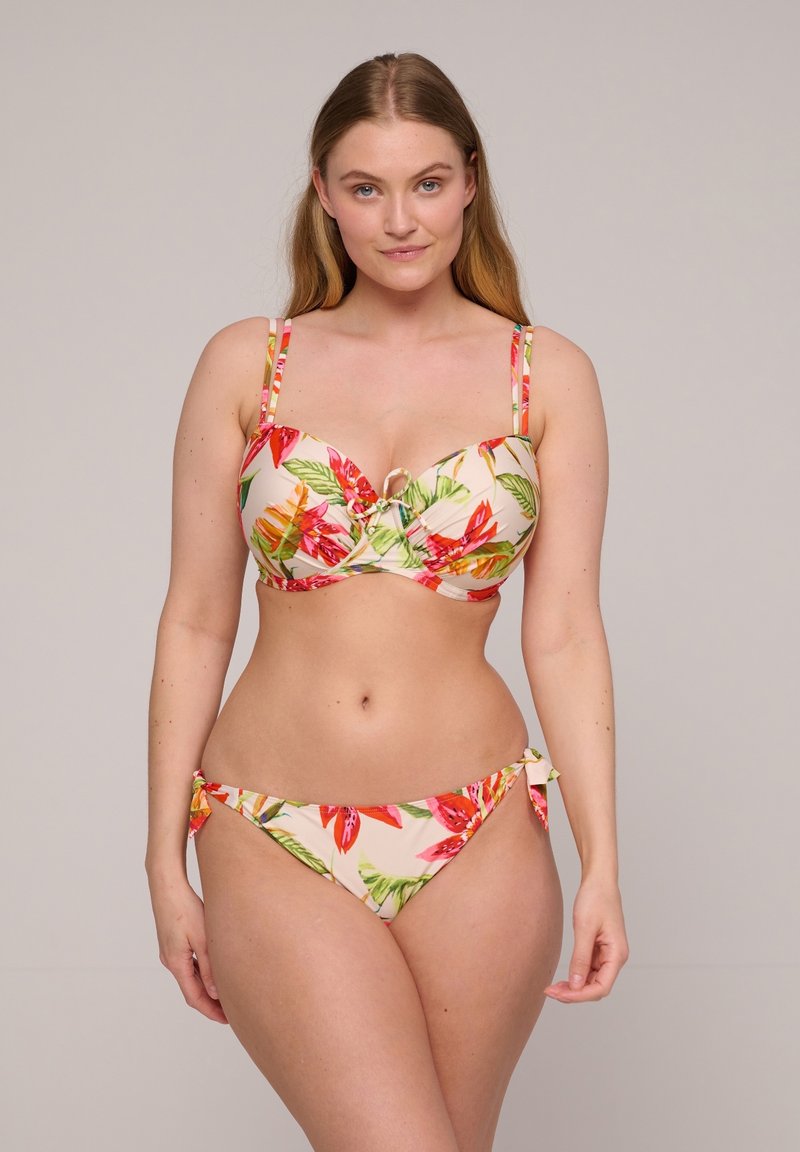 Floral bikini set with a cream background, featuring vibrant red and green tropical patterns. Top has underwire and adjustable straps; bottom tied at sides.