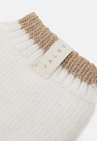Gants sans doigts en mélange de laine couleur crème avec un poignet texturé beige. Comprend une étiquette en tissu de marque cousue dans le poignet.