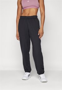 Melnas sporta bikses ar elastīgu jostu un apkaklītēm, izgatavotas no gludas auduma. Satur Adidas logo smalkā dizainā.