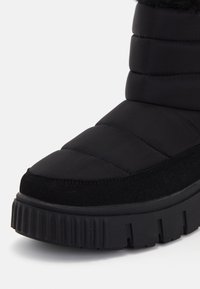 Schwarzer isolierter Stiefel mit gepolstertem Schaft, horizontalen Nähten, einer abgerundeten Zehenpartie und einer dicken geriffelten Sohle für besseren Halt.