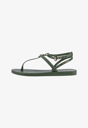 Sandalo verde piatto con sottili cinturini, anello per l'alluce, fibbia regolabile alla caviglia e suola testurizzata, marchiato con "Ipanema" sulla cinghia laterale.