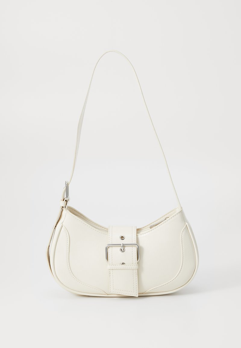 Sac à main en cuir blanc avec une forme arrondie, un accent de boucle en argent et une seule sangle réglable. Texture lisse et design minimaliste.
