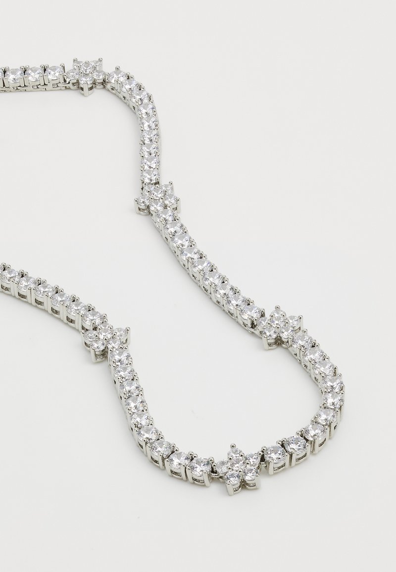 Silverfärgad halsband med en symmetrisk design som har runda och stjärnformade klara ädelstenar, som växlar i en delikat arrangemang.