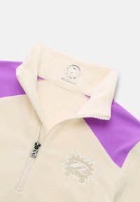 Creme fleece pullover med lilla accenter, halv-zip front og broderet logo. Har en stående krave og tekstureret stof.