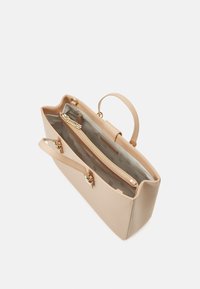 Sac à main en cuir beige avec une poche intérieure zippée, des poignées doubles et une texture lisse. Doté de quincaillerie dorée et d'un motif de doublure subtil.