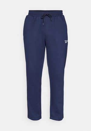 Tumši zilas treniņbikses, izgatavotas no mīkstas auduma, ar elastīgu jostas vietu un auklu, kā arī Reebok logo uz kreisās augšstilba.