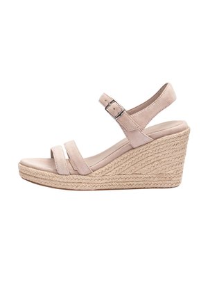 Beżowy sandał na koturnie z plecioną platformą z liny, dwoma przednimi paskami oraz regulowanym paskiem wokół kostki z metalową klamrą.
