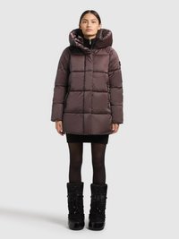 Kurtka puchowa w ciemnym kolorze mauve, z kapturem, pikowanym wzorem i zapinana na zamek z przodu. Nosi się ją z sukienką-sweterkiem i czarnymi wysokimi botkami do kolan.