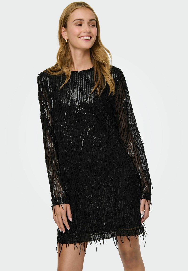 Robe noire à manches longues, ornée de sequins verticaux et de franges au niveau de l'ourlet. Le matériau transparent crée de la texture et un intérêt visuel.