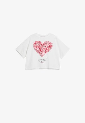 White cropped T-shirt with short sleeves featuring a red heart design made of small shapes and the text "Be proud to love who you are."