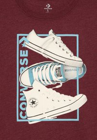 Grafika dvou tenisek Converse—jedny vysoké bílé s černými akcenty, jedny nízké světle modré a bílé—na tmavě červeném pozadí.