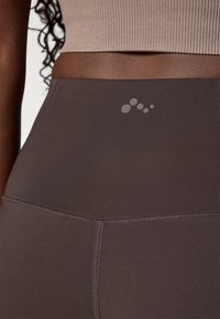 Højtaljede mørkegrå leggings lavet af glat, strækbart materiale, med en diskret logo-detalje og flade syninger for en ren finish.