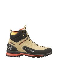 Bota de senderismo con una parte superior de ante beige, detalles en negro, suela roja y acentos amarillos. Presenta ojales de metal y una puntera reforzada.