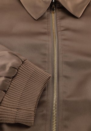 Braune Bomberjacke mit goldenen Reißverschluss, glatter Satin-Oberfläche, gerippten Bündchen und klassischem spitzem Kragen.