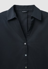 Camicia nera con colletto e bottoni, dotata di tre bottoni visibili e un'etichetta del marchio all'interno del collo che indica "CALLIOPE" in taglia piccola.