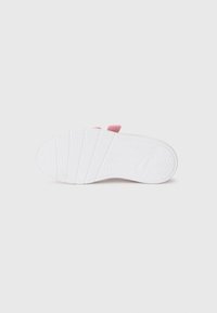 Semelle de sneaker blanche avec un motif de grip texturé, dotée d'un accent rose au niveau du talon. Matériau en caoutchouc lisse et design minimal.