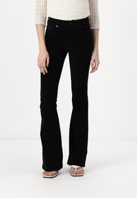Jeans acampanados negros hechos de una mezcla de algodón, con una cintura alta, cierre frontal de botón y estilo de cinco bolsillos. Textura suave.