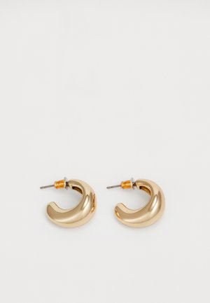 Dos pendientes de aro dorados brillantes en un diseño curvado, con acentos naranjas cerca del poste, sobre un fondo blanco liso.