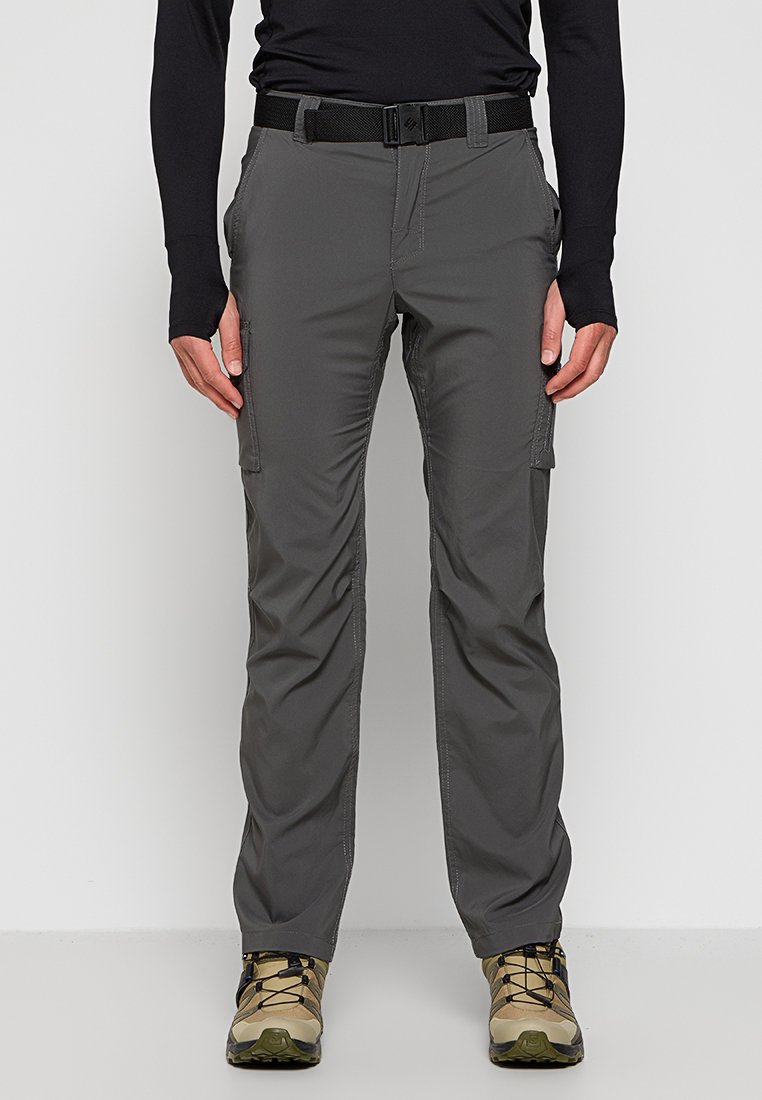 Graue Cargo-Hosen aus strapazierfähigem Material, mit mehreren Taschen, einem Reißverschluss und einem taillierten Bund. Kombiniert mit hellen Wanderschuhen.