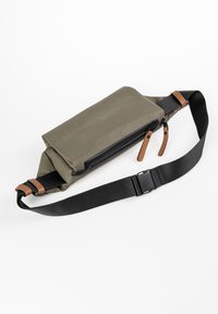 Olijfgroene nylon heuptas met een zwarte rits, tan leren accenten, een verstelbare zwarte band en een slank rechthoekig ontwerp.