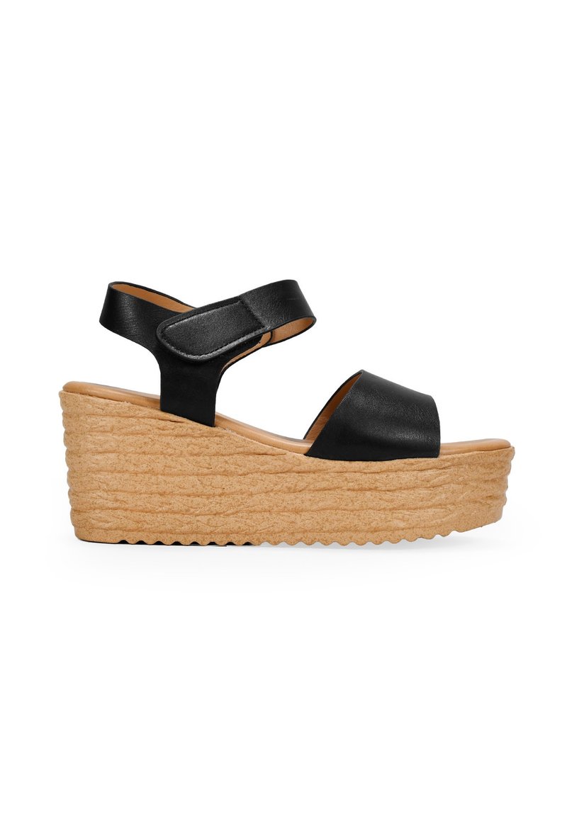 Sandale à talon compensé en cuir noir avec large bride et fermeture ajustable à la cheville. Plateforme en jute texturée avec un design à couches.