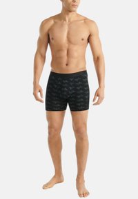 Svarta boxershorts med ett geometriskt mönster, tillverkade av mjukt tyg, med resårmidja och åtsittande design.