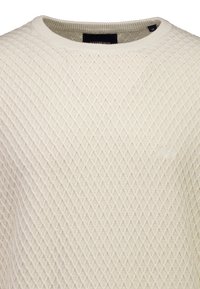 Helles cremefarbenes Strickpullover mit einem strukturierten Diamantmuster, rundem Ausschnitt und Markenetikett am Innenkragen.