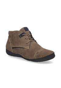 Bottes chukka en suède marron avec des accents navy, présentant un bout arrondi, un système de laçage et des détails cousus sur l'empeigne et la semelle.