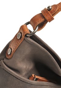 Grijze leren handtas met een bruine leren schouderband, voorzien van metalen hardware en een zachte, gestructureerde afwerking. De binnenkant bevat een kleine bruine accenten.