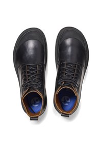 Scarpe di pelle nere con punta arrotondata, dotate di suola in gomma testurizzata, design con lacci e dettagli color tan all'interno del colletto e della suola.