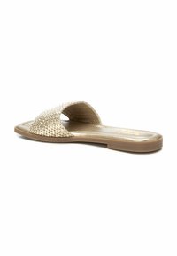 Sandal de slide tejido en color beige con suela plana, punta abierta y diseño minimalista. Presenta un forro interior suave y una tira superior texturizada.
