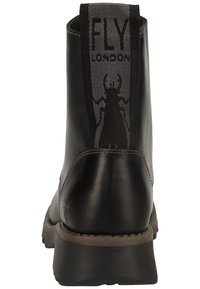 Stivale alla caviglia in pelle nera con una pannello elastico grigio testurizzato etichettato "FLY LONDON." Presenta una suola robusta e un design a punta arrotondata.