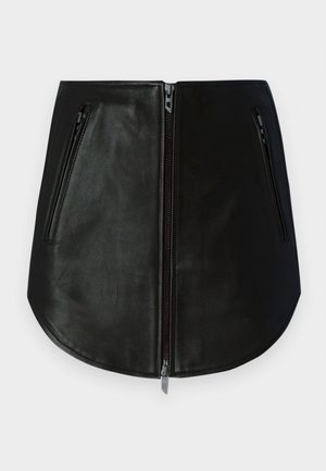 Mustan nahkainen minihame, jossa on kaksi vetoketjullista taskua edessä. Siinä on sileä pinta ja kaareva helma. Vetoketjut ovat metallisia.