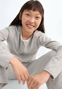 Grå bomullsnattkläder, med en långärmad cardigan med knäppning och matchande byxor. Mjukt material och avslappnad passform.