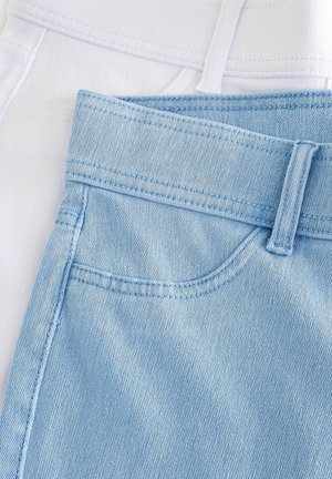 Due paia di jeans esposti: uno in denim bianco e l'altro in denim azzurro chiaro. Entrambi presentano cuciture e dettagli della cintura distintivi.
