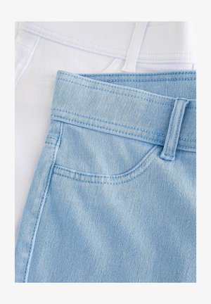 Due paia di jeans esposti: uno in denim bianco e l'altro in denim azzurro chiaro. Entrambi presentano cuciture e dettagli della cintura distintivi.