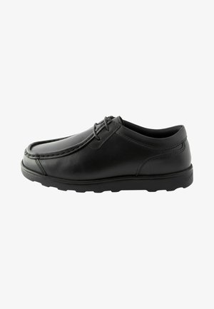 Scarpa in pelle nera con punta arrotondata, dettagli di cucitura e suola in gomma bassa. Presenta lacci e una texture superficiale liscia.
