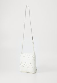 Biała pleciona torebka o prostokątnym kształcie, z cienkim paskiem, subtelnymi detalami w szyciu i fakturowaną powierzchnią.