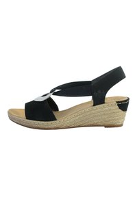 Sandalo wedge in suede nero con cinturino regolabile, piattaforma in juta intrecciata e un accento metallico sulla parte anteriore. Soletta imbottita per il comfort.