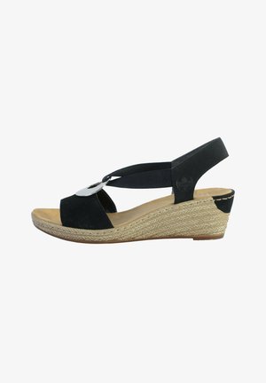 Black suede wedge sandal with an adjustable strap, woven jute platform, and a metallic accent on the front. Cushioned footbed for comfort.