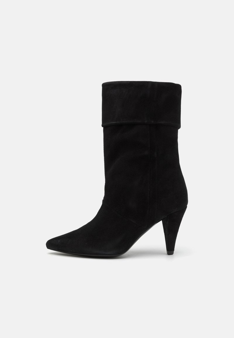 Botă neagră din suede până la gleznă, cu manșetă pliată, vârf ascuțit și toc subțire de 5 cm. Textură netedă cu o siluetă elegantă.